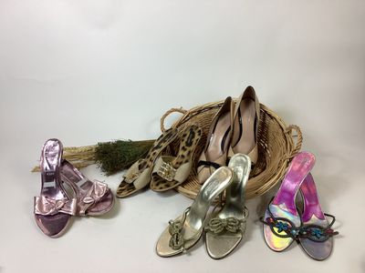 several pairs of women ' s shoes are sitting on a table next to a basket