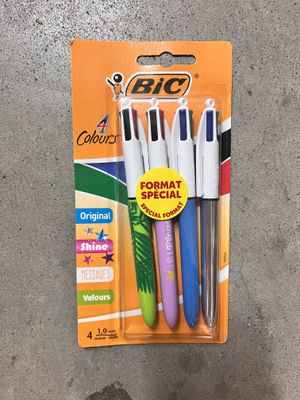 three different colored pens are in a package on the floor