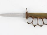 a small knife with a brass handle on a white surface