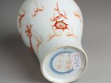 a white vase with a red and blue design on it