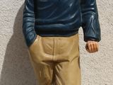 une figurine représentant un homme debout sur un socle