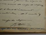 an old book with writing on it sitting on a table