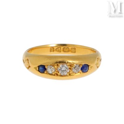 un gros plan d'une bague en or jaune sertie de saphirs et de diamants
