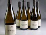 six bouteilles de vin sont alignées sur une table