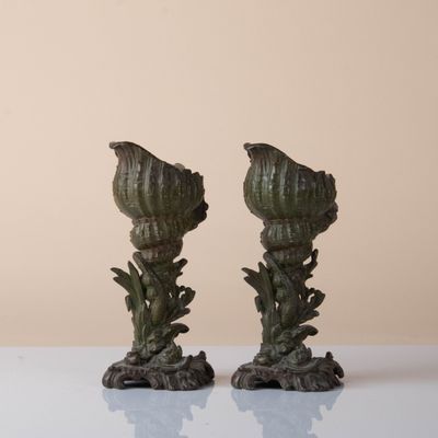 pair of green artichokes on a white table with a beige background