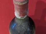 a bottle of liquor sitting on a table with a red wall in the background