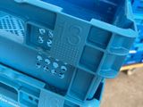 two blue plastic crates stacked on top of each other in a warehouse