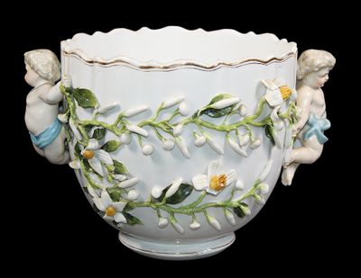 un vase blanc orné de fleurs et d'anges