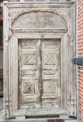 doorway of a brick building with a wooden door and a brick wall