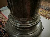 a silver vase sitting on top of a rug on the floor