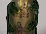 a small glass bottle with a painting on it