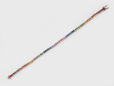 un gros plan d'un bracelet coloré en perles posé sur une surface blanche