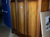 a wooden cabinet in the middle of a room with boxes on the floor