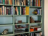 a computer sitting on a desk in front of a bookshelf