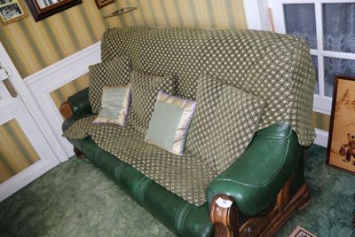 un canapé en cuir vert recouvert d'une housse verte dans un salon