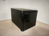 a small black computer sitting on a wooden table