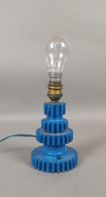 a blue light bulb sitting on top of a blue gear
