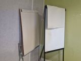 a black suitcase sitting in front of a whiteboard in a room