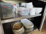 beaucoup d'assiettes et de bols sur l'étagère de la cuisine