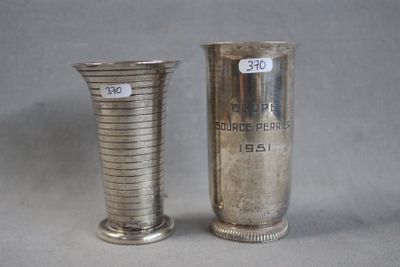 two silver vases sitting next to each other on a table