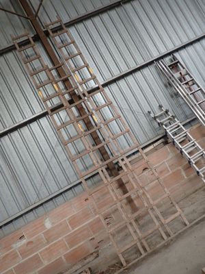 une échelle appuyée contre un mur, à côté d'un mur de briques