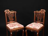 a pair of antique chairs with floral upholstered cushions