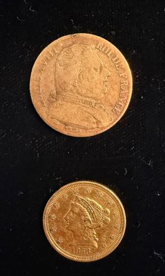 two different types of gold coins on a black surface