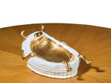 a gold frog figurine sitting on top of a wooden table