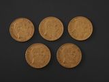four gold sovereigns on a black background