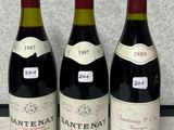 trois bouteilles de vin rouge sont alignées sur un comptoir