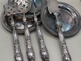 trois cuillères en argent et une assiette en argent sur le comptoir