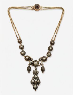 un collier en or orné de perles noires et blanches et d'une chaîne en or