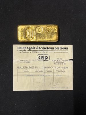 a close up of a piece of paper with a gold bar on it