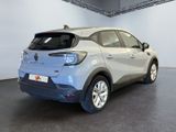 the rear of a silver car in a showroom with a black floor