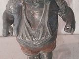 une statue représentant un homme coiffé d'un chapeau, posée sur un socle