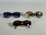 three pairs of sunglasses are sitting on a white surface