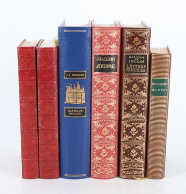 plusieurs livres sont alignés sur une surface blanche