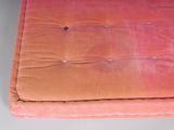 a futon chair with a pink cover on it