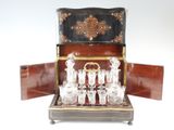 des bouteilles et des verres dans un coffret en bois posé sur une surface blanche