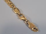a close up of a gold chain on a white surface