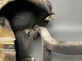 an antique bronze elephant head with a long trunk and a long trunk