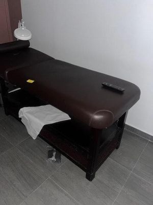 une table de massage recouverte d'une serviette, dans une pièce