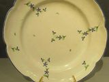 a yellow plate with purple flowers on it