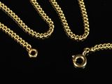 a close up of a gold chain on a black background