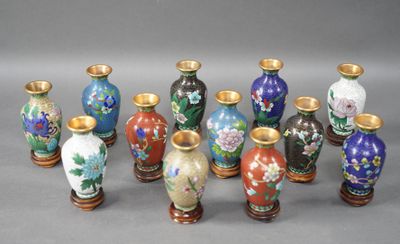sept vases ornés de motifs variés, posés sur un fond gris