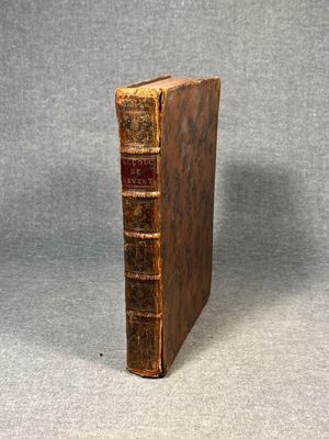 an old book sitting on top of a table next to a gray background