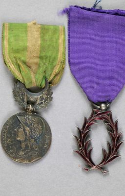 un ruban violet et vert orné d'une couronne d'épines et une médaille sur laquelle figure une couronne d'épines