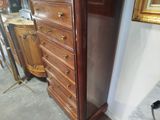 a tall wooden dresser with a mirror on top of it