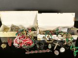 une boîte blanche remplie de bijoux variés, posée sur une table