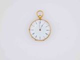 a close up of a pocket watch on a white surface